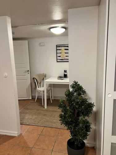 uma sala de jantar com uma mesa e um vaso de plantas em Källarlägenhet Örgryte em Gotemburgo