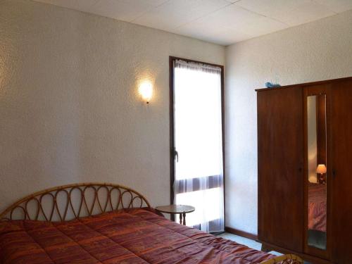 une chambre avec un lit et une porte coulissante en verre dans l'établissement Appartement à 50m de la plage, 2 Chambres, 1 Balcon, Quartier du Port Tranquille - FR-1-229D-77, à Fleury