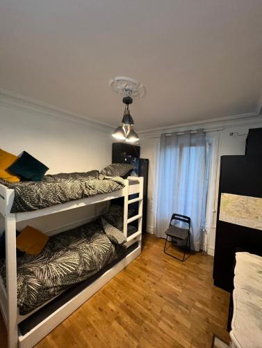 - une chambre avec deux lits superposés et une lumière dans l'établissement Charmant 3 pièces Champs-Elysées, Ternes, Porte Maillot, 17ème, à Paris