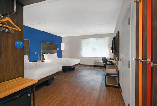 a hotel room with two beds and a blue wall at Tru By Hilton Burlington in Burlington