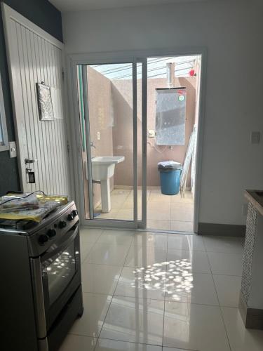 uma cozinha com um fogão e vista para uma casa de banho em BELÍSSIMA CASA ILHABELA em Ilhabela