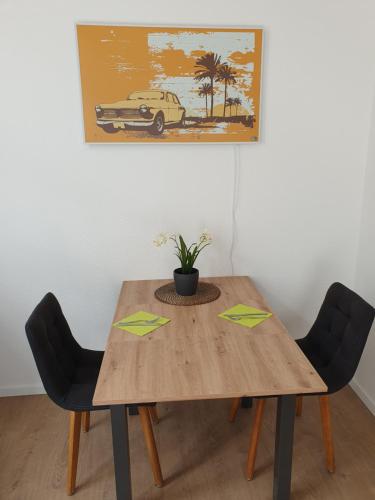 a dining room table with two chairs with green arrows at Appartement im Herzen von Langenberg in Velbert