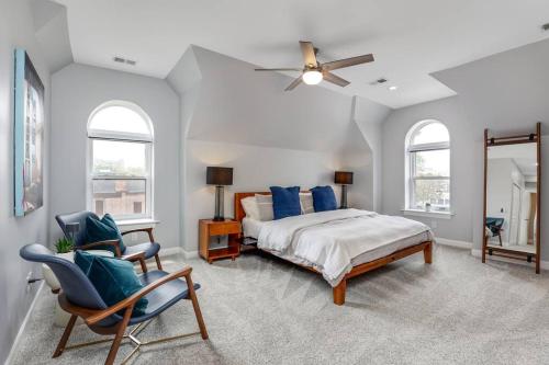 a bedroom with a bed and two chairs and a ceiling fan at The Lumber Baron's Penthouse 3BR / 2.5 BA in Detroit