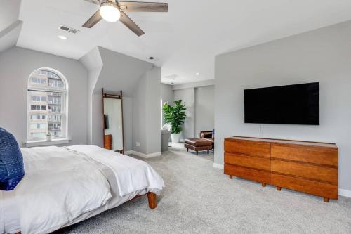 a bedroom with a bed and a flat screen tv at Lumber Barons Detroit Brush Park Penthouse 3BR 2 Kings 1 Queen 2 Baths 1 Car Garage in Detroit