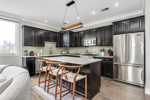 a kitchen with a large island with bar stools at Lumber Barons Detroit Brush Park Penthouse 3BR 2 Kings 1 Queen 2 Baths 1 Car Garage in Detroit