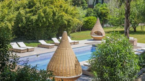 three large baskets sitting next to a swimming pool at Luxurious royal estate in historic Sintra paradise in Sintra