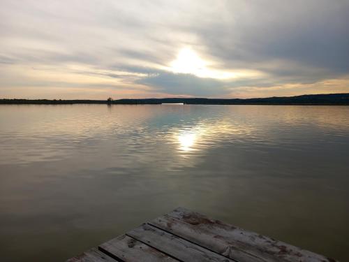 a view of a lake with the sun setting at Kisfaludy Apartment House in Gárdony