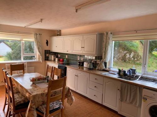 a kitchen with a table and a table and chairs at Spacious Cottage in Meenaleck near Gweedore County Donegal in Donegal
