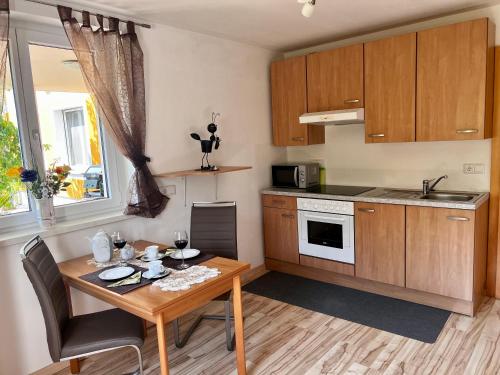 uma pequena cozinha com uma mesa de madeira e uma sala de jantar em Appartement Christine em Sankt Johann im Pongau