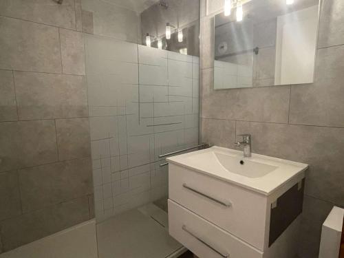 une salle de bain blanche avec un lavabo et un miroir dans l'établissement Charmant appartement à Praz Sur Arly - 5 personnes, parking et casier à ski - FR-1-603-13, à Praz-sur-Arly