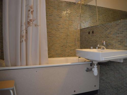 une salle de bain avec un lavabo, une baignoire et un miroir dans l'établissement Studio cabine 4 pers. avec balcon, piscine, parking, accès direct plage - Grau-du-Roi - FR-1-250-157, au Grau-du-Roi