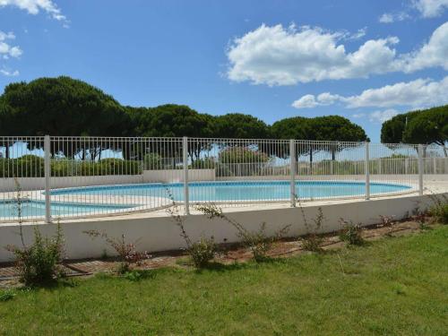 einen Zaun um einen Pool im Hof in der Unterkunft Appartement Port Camargue, 1 pièce, 4 personnes - FR-1-250-157 in Le Grau-du-Roi