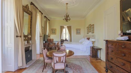 1 dormitorio con 1 cama, mesa y sillas en Luxurious royal estate in historic Sintra paradise, en Sintra