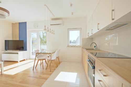 a kitchen with a table and a dining room at Niebieski Kwadrat - garaż podziemny + AC! in Rzeszów