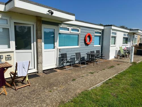 a trailer with chairs and a table in front of it at 2 Bedroom Chalet SB22, Sandown Bay, Isle of Wight, Dog Friendly in Sandown