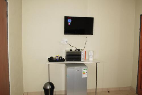 a small table with a tv on top of a wall at EMPEROR LODGE AND TOURS in Germiston