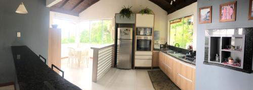 a kitchen with a stainless steel refrigerator and a table at Casa Barra da lagoa/ Mole in Florianópolis
