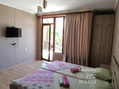 a bedroom with a bed and a large window at Villa Platinum in Tskaltubo