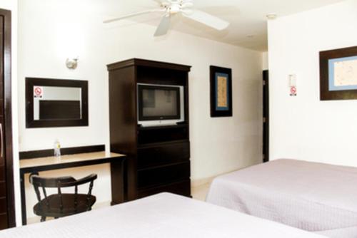 a bedroom with a bed and a tv and a chair at Maxihotel Business Class Culiacan in Culiacán