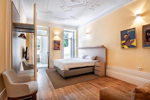 a bedroom with a bed and a chair at Downtown Grand Houses in Porto