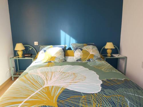 - un lit avec une couette colorée et 2 tables de chevet dans l'établissement Maison 3* à 350m de la mer, jardin sud, terrasse, 3 chambres, parking, vélos dispo à Trégastel - FR-1-368-289, à Trégastel