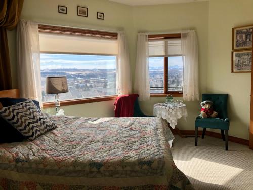 sypialnia z łóżkiem, krzesłem i oknem w obiekcie Rocky Mountain View Bed & Breakfast w mieście Cochrane