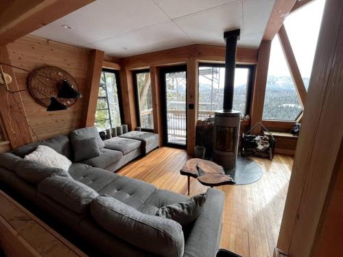 a living room with a couch and a fireplace at Basecamp Strathcona Park View Chalet in Mount Washington