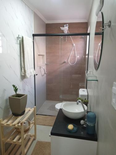 a bathroom with a shower with a sink and a toilet at Suíte confortável - banheiro privativo! in Sao Paulo