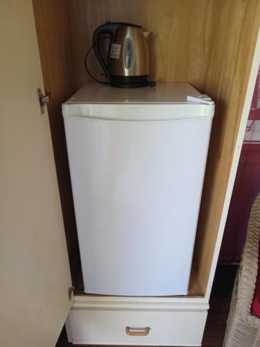 a microwave sitting on top of a refrigerator at Apartment Unforgetable Gardens in Falmouth