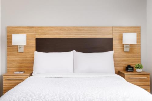 una camera da letto con un grande letto bianco con due lampade di TownePlace Suites Manchester-Boston Regional Airport a Manchester