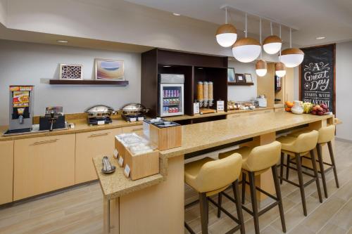 a kitchen with a counter with bar stools at TownePlace Suites Manchester-Boston Regional Airport in Manchester