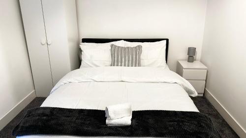 um quarto com uma cama branca e um cobertor preto em Comfortable Modern Bedroom Space with Ensuite near Bramall Lane Stadium and RHH em Sheffield