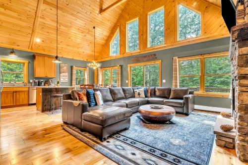 a living room with a couch and a table at Ski Chalet 6 min to Sunday River - Hot Tub, Home Theater, Game Room, Fire Pit - Sleeps 12 in Bethel