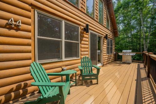 two chairs and a table on the front porch of a cabin at Ski Chalet 6 min to Sunday River - Hot Tub, Home Theater, Game Room, Fire Pit - Sleeps 12 in Bethel