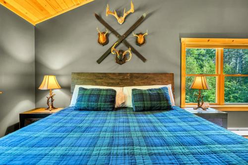 a bedroom with a blue bed with antlers on the wall at Ski Chalet 6 min to Sunday River - Hot Tub, Home Theater, Game Room, Fire Pit - Sleeps 12 in Bethel