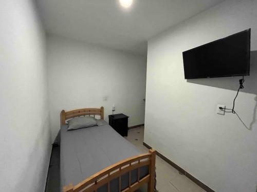 - une chambre avec un lit et une télévision à écran plat dans l'établissement Q'entiHospedaje San Blas 3, à Cusco