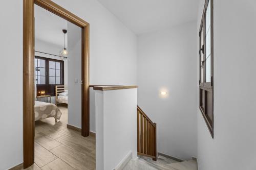 a hallway with a white wall and a mirror at Casahost Casa Ahul Family Time in Costa Teguise