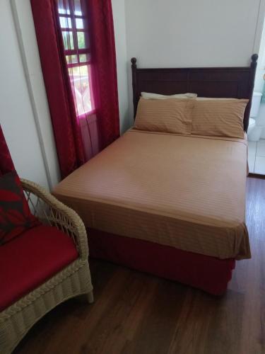 a bed and a chair in a room at Apartment Unforgetable Gardens in Falmouth