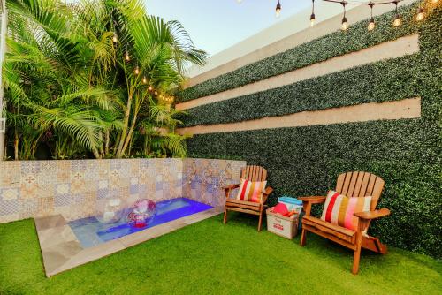 duas cadeiras e uma piscina num quintal com uma parede em Privada Stays - Lofts with Private Pool and Oasis, near Eagle Beach em Palm Beach