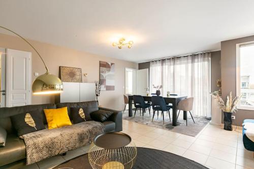 uma sala de estar com um sofá e uma sala de jantar em Appartement climatisé T3 chic à Strasbourg avec billard et terrasse em Estrasburgo