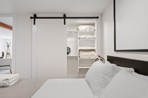 een witte slaapkamer met een bed en een kast bij Rare Redesign Cozy Space, Quaint Local Location in Camas