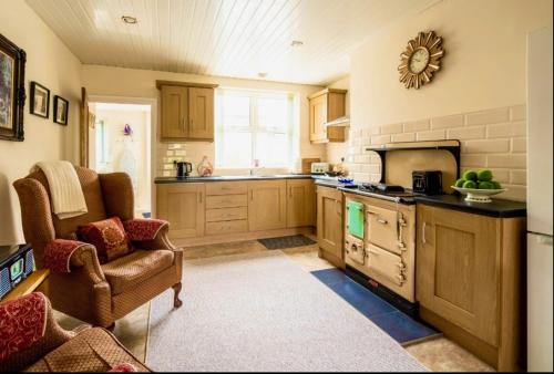 een keuken met een bank en een stoel in een kamer bij Lime Tree House in Maguires Bridge