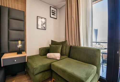 a living room with a green couch and a window at Beautiful Gem at Ellipse in Midrand
