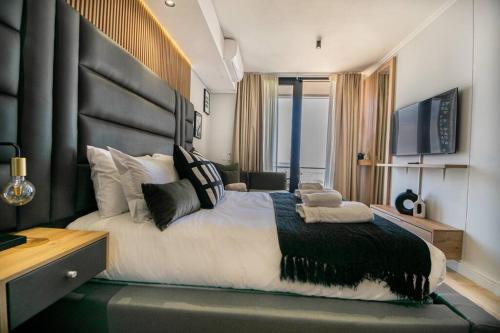 a bedroom with a large bed with a black headboard at Beautiful Gem at Ellipse in Midrand