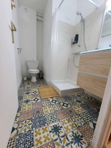 bagno con servizi igienici e pavimento piastrellato. di Joli studio rénové situé au pied des thermes ad Amélie-les-Bains-Palalda