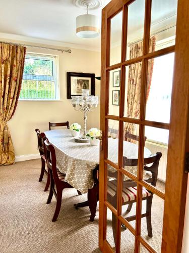 Maguires BridgeにあるLime Tree Houseのテーブルと椅子と窓のあるダイニングルーム