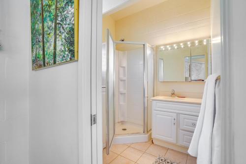 uma casa de banho branca com um chuveiro e um lavatório. em Honolulu Hideaway with Balcony City and Ocean View! em Honolulu