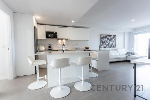 a kitchen and living room with a counter and chairs at Luxury Apartment with 2 Bedrooms in Canet d'en Berenguer, Valencia in Canet de Berenguer