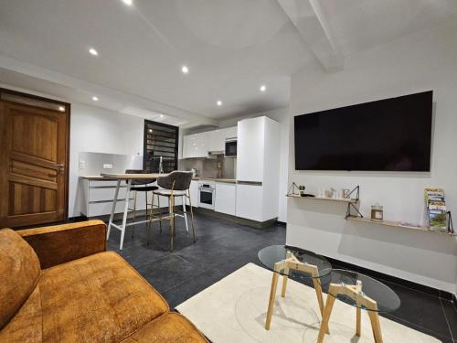 een woonkamer met een bank en een flatscreen-tv bij ECOLODGY Suites Villa in Ducos