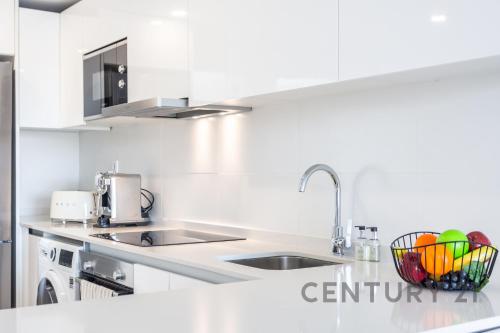 a white kitchen with a sink and a bowl of eggs at Luxury Apartment with 2 Bedrooms in Canet d'en Berenguer, Valencia in Canet de Berenguer